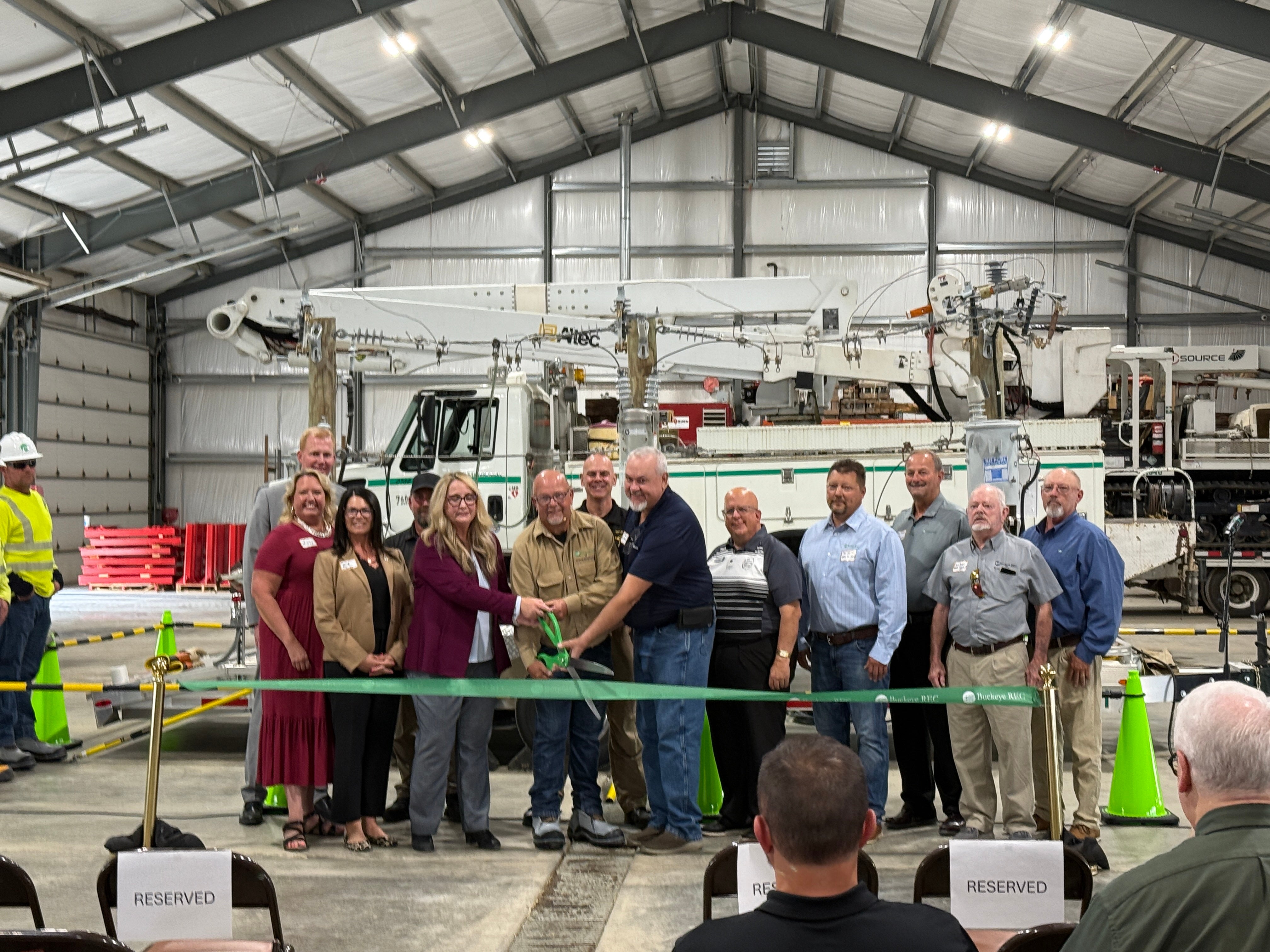 A group of people at a ribbon cutting for a live line safety trailer